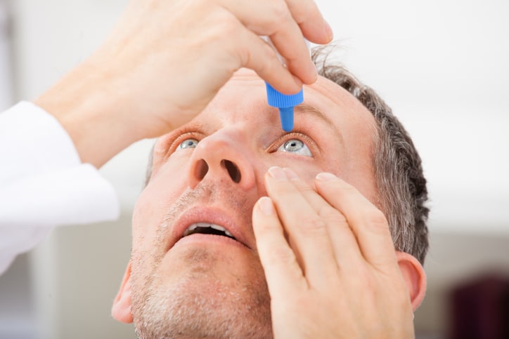 Close-up Of A Mature Man Putting Eye Drops In Eyes