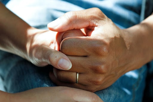 two hands holding, one wearing ring- thyroid eye disease
