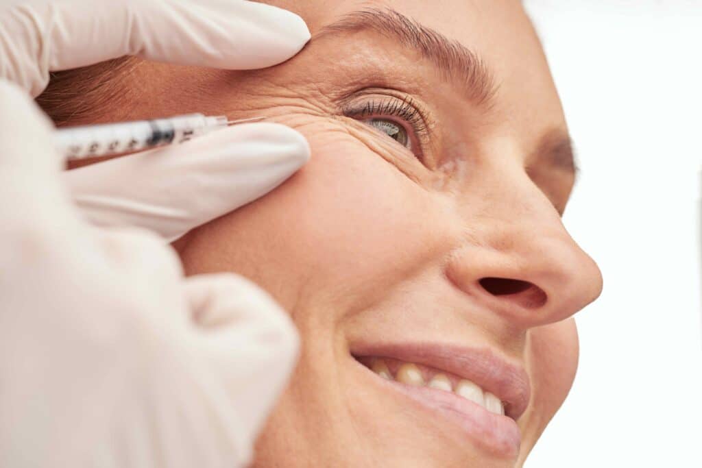 Beauty procedure. Close up of a beautiful mature woman receiving hyaluronic acid injection by beautician